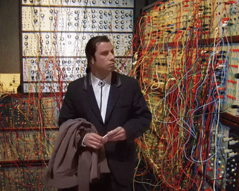 Confused Jon Travolta with complex wiring system in the background.